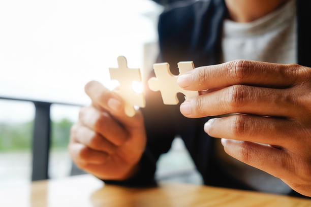 Business woman hands connecting jigsaw puzzle. Business solutions, success and strategy concept. Businessman hand connecting jigsaw puzzle.Close up photo with selective focus.